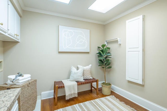 living area featuring wood-type flooring and ornamental molding