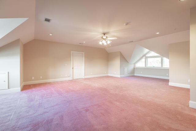 additional living space with ceiling fan, light colored carpet, and vaulted ceiling