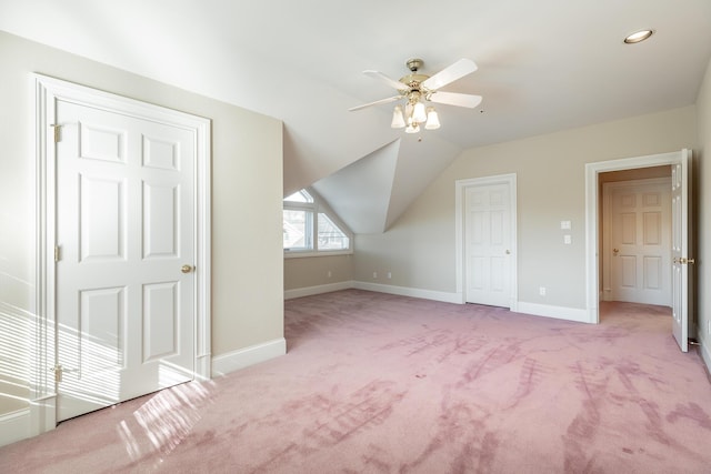 additional living space with ceiling fan, light colored carpet, and vaulted ceiling