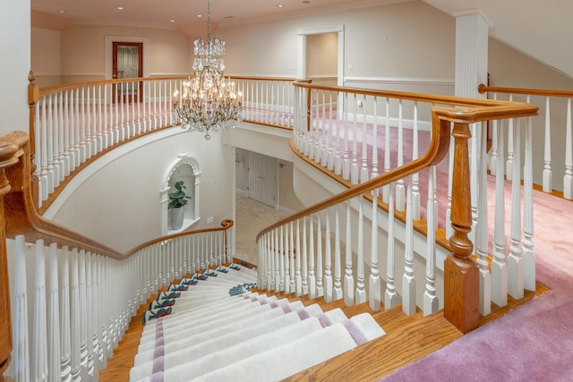 stairs featuring ornamental molding and an inviting chandelier