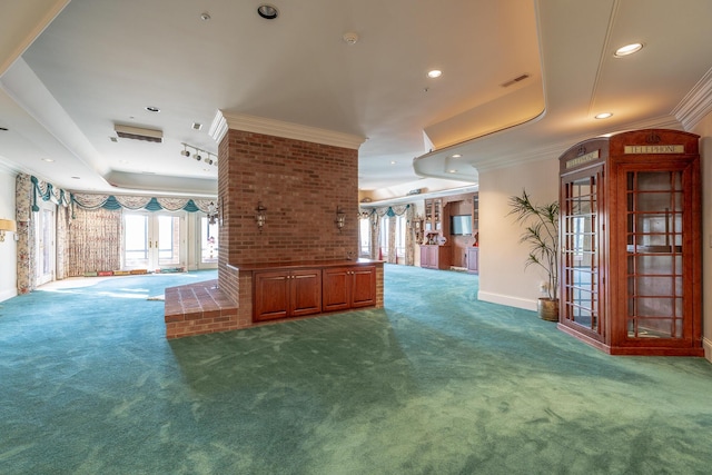 interior space featuring a tray ceiling, crown molding, and carpet floors