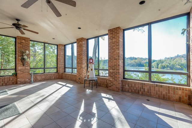 unfurnished sunroom with ceiling fan and plenty of natural light