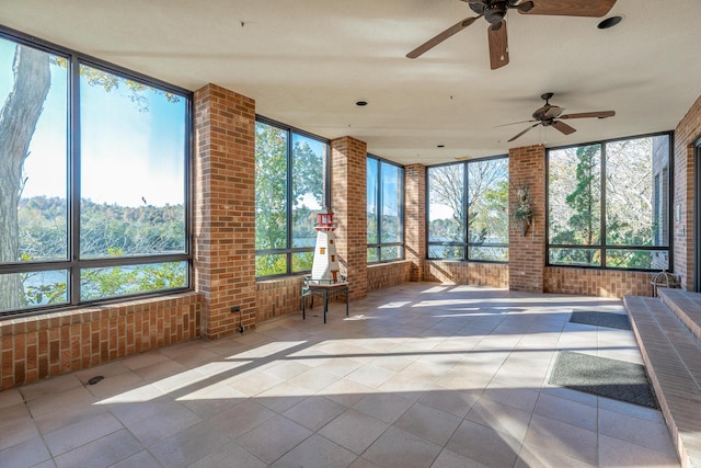 unfurnished sunroom featuring ceiling fan