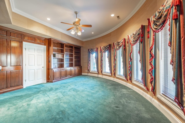 unfurnished living room with carpet flooring, ceiling fan, crown molding, and a wealth of natural light