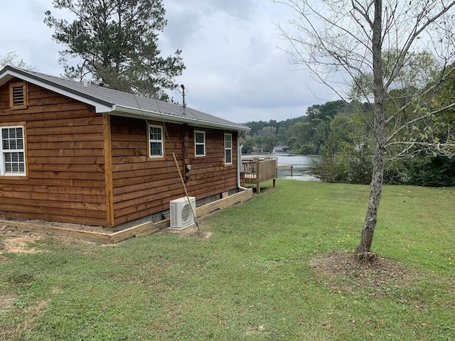 view of home's exterior featuring a deck with water view, a yard, and cooling unit