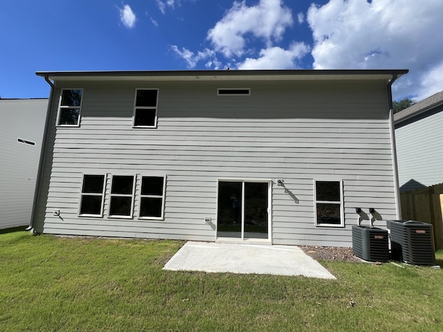 back of property featuring a lawn, a patio, and central AC