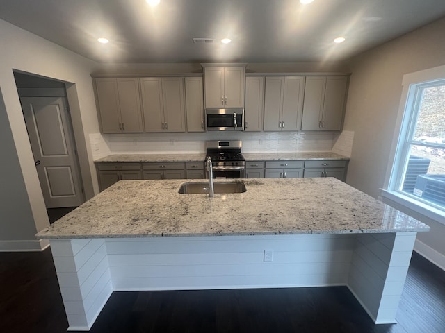 kitchen with gray cabinetry, sink, stainless steel appliances, dark hardwood / wood-style floors, and decorative backsplash