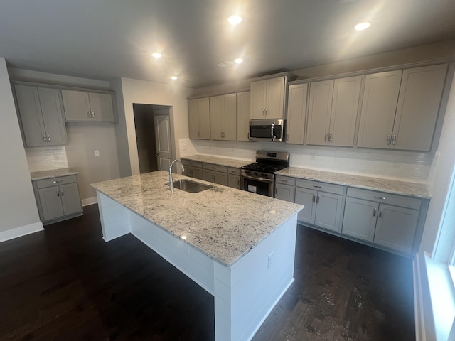 kitchen featuring a center island with sink, gray cabinetry, sink, and appliances with stainless steel finishes