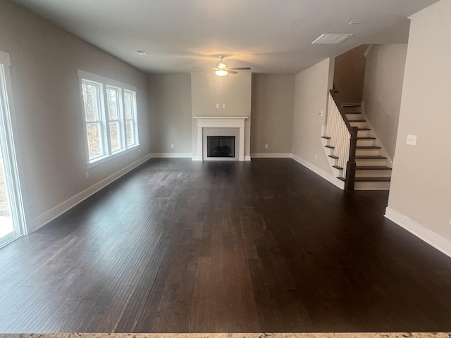 unfurnished living room featuring ceiling fan and dark hardwood / wood-style flooring