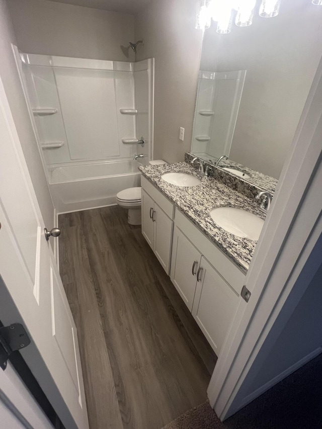 full bathroom with vanity, wood-type flooring,  shower combination, and toilet