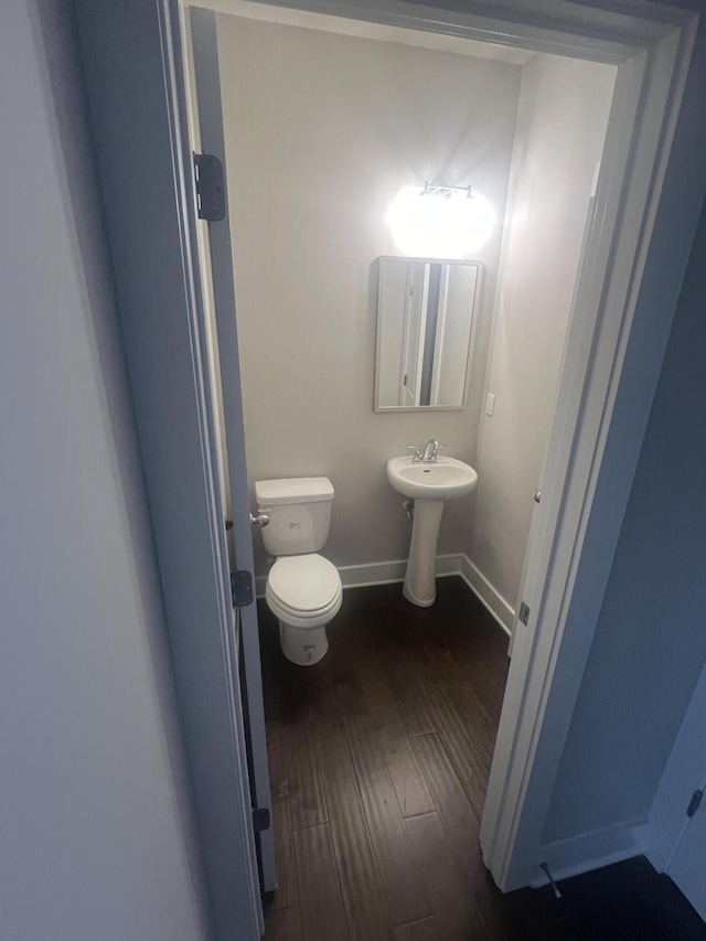 bathroom with wood-type flooring, toilet, and sink