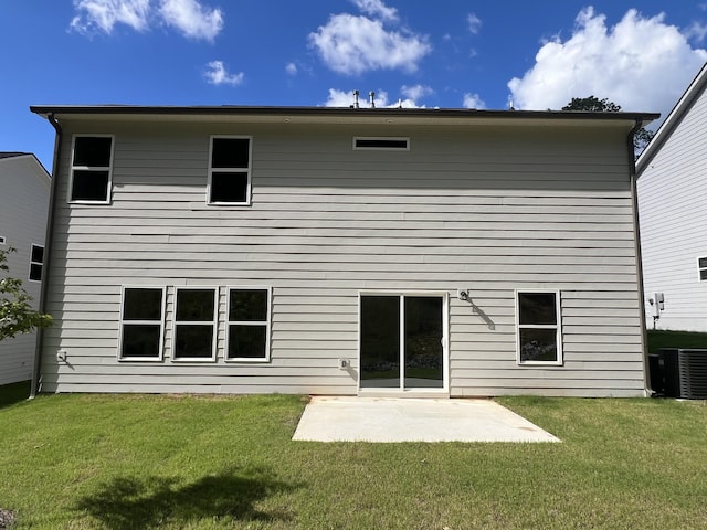 rear view of house with a lawn, cooling unit, and a patio