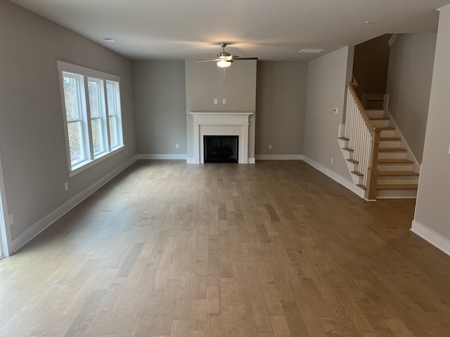 unfurnished living room featuring light hardwood / wood-style flooring and ceiling fan