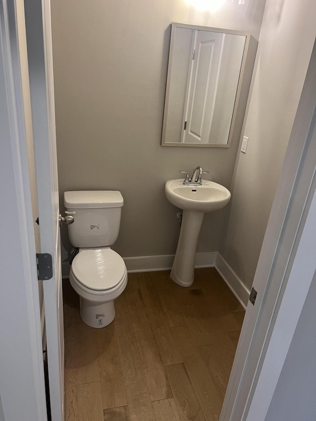 bathroom with hardwood / wood-style floors, toilet, and sink