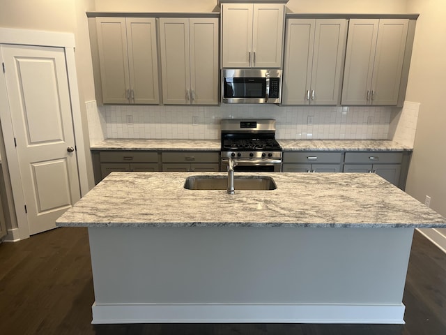 kitchen featuring stainless steel appliances, gray cabinets, and light stone counters