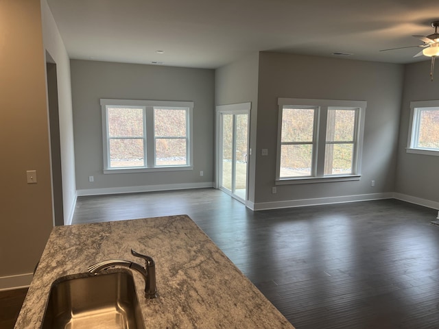 living room featuring ceiling fan, sink, and dark wood-type flooring