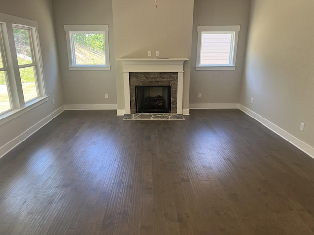 unfurnished living room featuring a fireplace and dark hardwood / wood-style floors