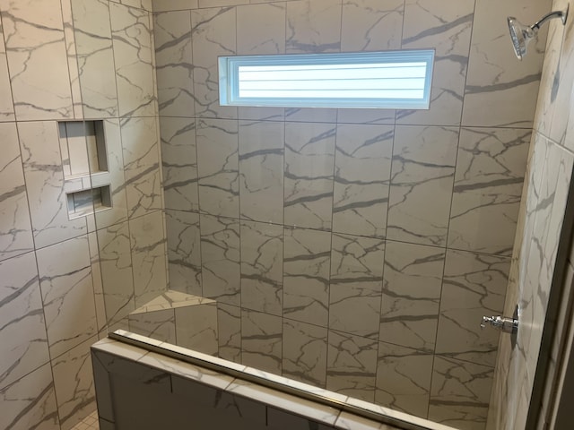 bathroom featuring tiled shower and a wealth of natural light