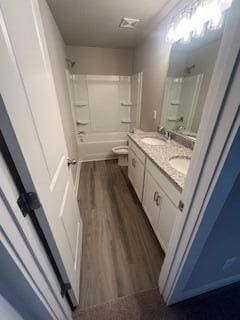 full bathroom with shower / bathing tub combination, vanity, toilet, and wood-type flooring