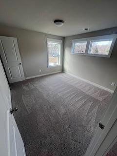 unfurnished bedroom with dark carpet