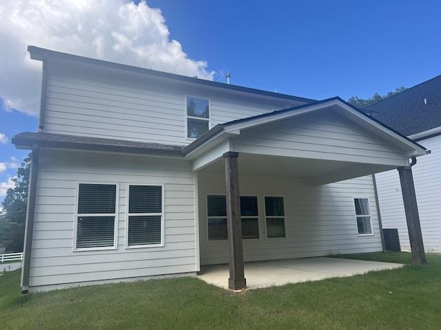 rear view of house with a lawn and a patio