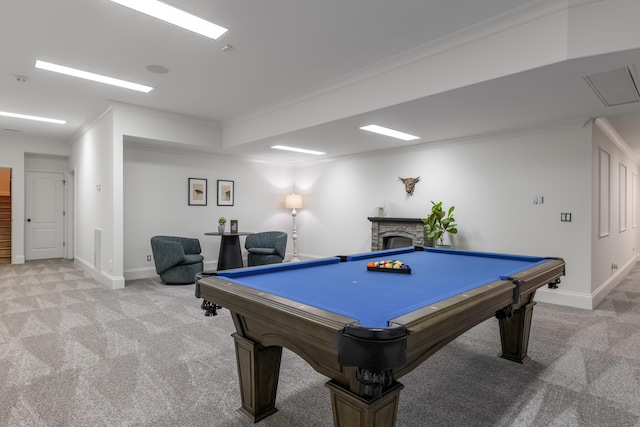 rec room with pool table, ornamental molding, a fireplace, and light carpet