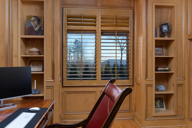 office space with built in features and light wood-type flooring