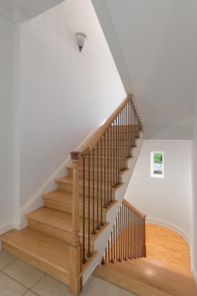 stairway with wood finished floors and baseboards