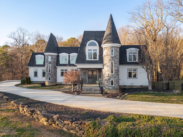 view of front facade with stone siding and fence