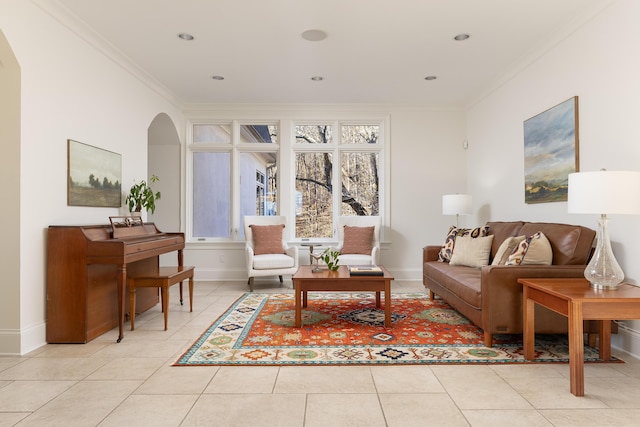 living area featuring light tile patterned floors, baseboards, arched walkways, and ornamental molding