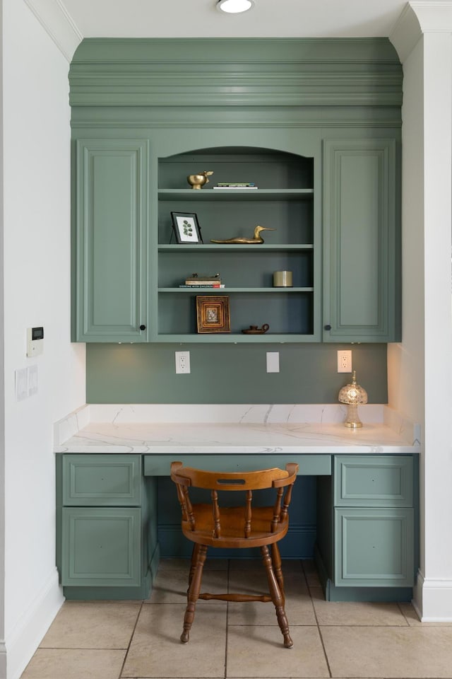 home office featuring light tile patterned flooring, baseboards, and built in desk