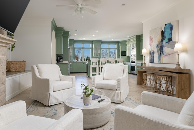 living area featuring light tile patterned floors, recessed lighting, ceiling fan, and ornamental molding