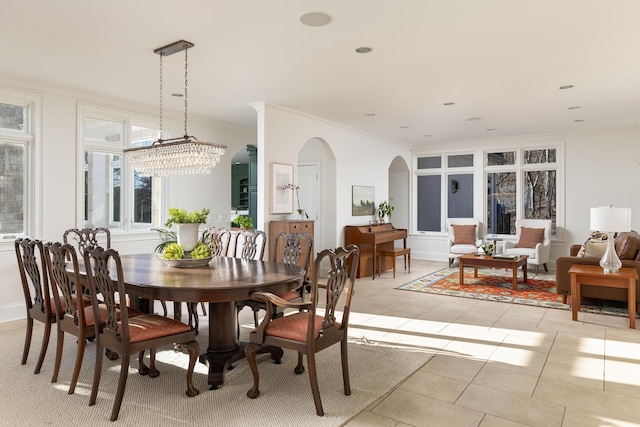 dining space with light tile patterned floors, a notable chandelier, recessed lighting, and crown molding