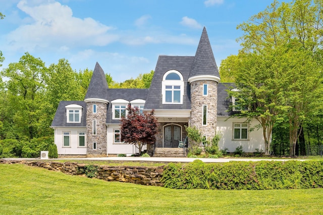 french country home featuring a front lawn, stone siding, and french doors