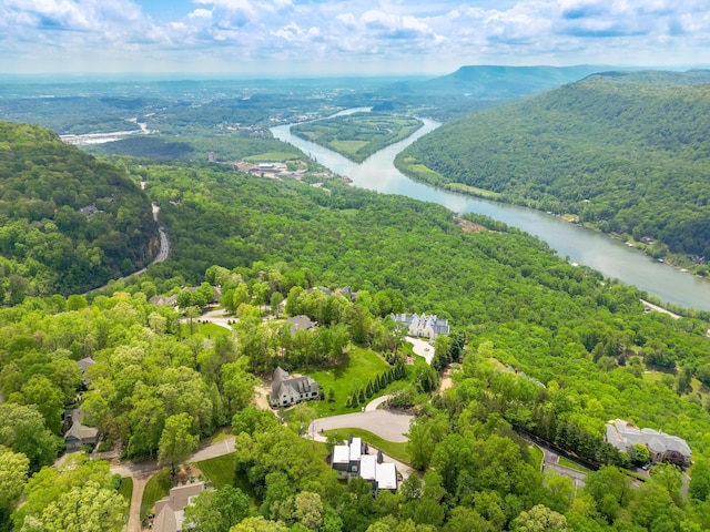drone / aerial view with a forest view and a water view