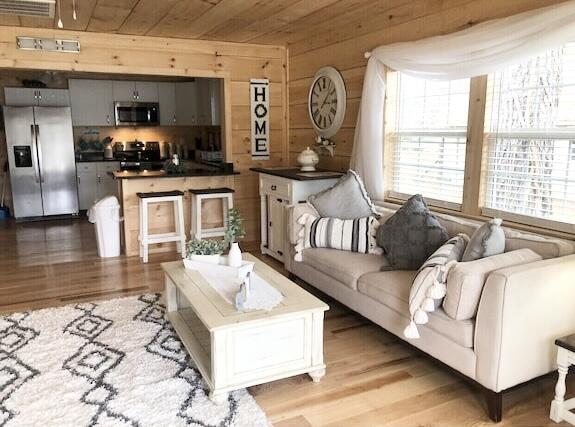 living room featuring light wood-type flooring, wood ceiling, and wood walls