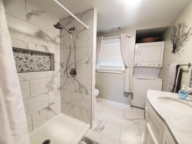 bathroom featuring toilet, vanity, stacked washing maching and dryer, and a shower with shower curtain