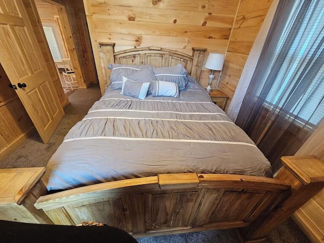 bedroom featuring wood walls and dark carpet