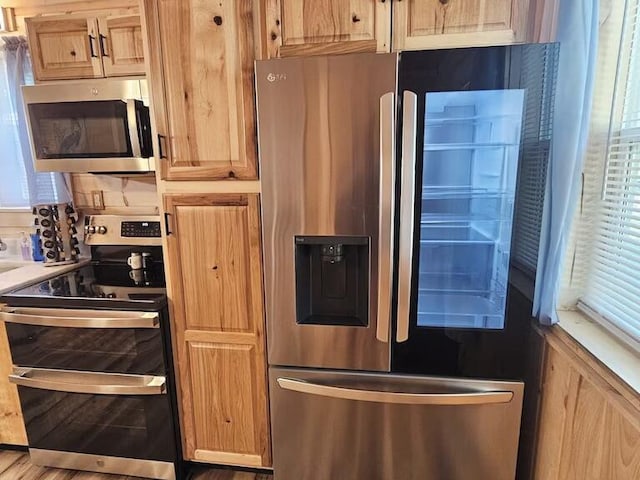 kitchen featuring light brown cabinetry and stainless steel appliances