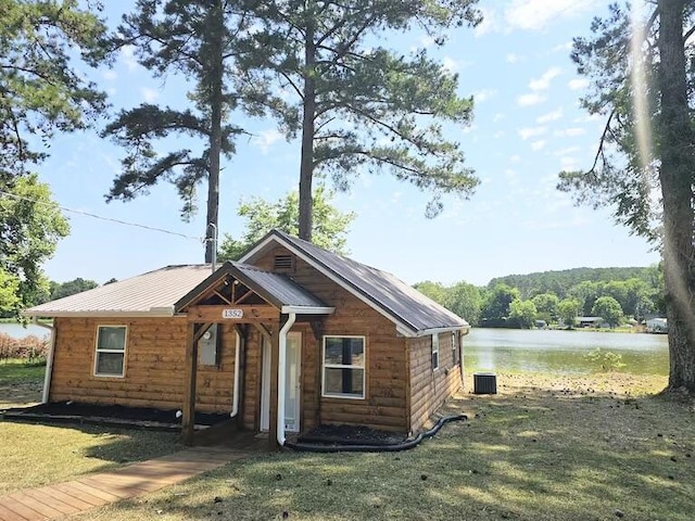 view of front of home with central AC, a water view, and a front lawn