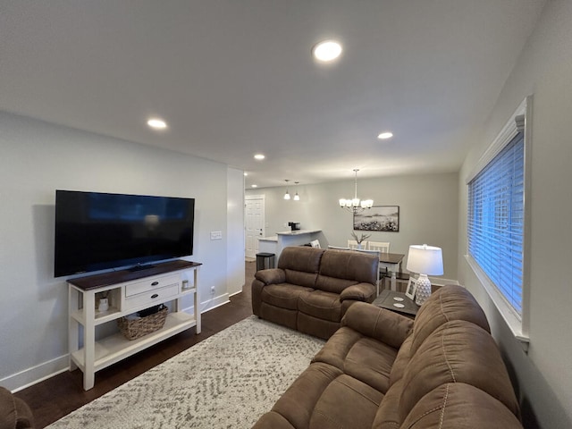 living room with dark hardwood / wood-style floors and a notable chandelier