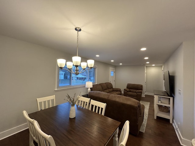 dining room with dark hardwood / wood-style flooring and an inviting chandelier