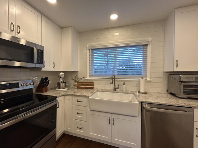 kitchen with sink, white cabinets, and appliances with stainless steel finishes