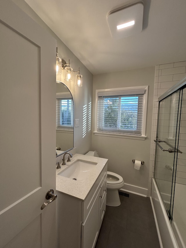 full bathroom featuring vanity, toilet, and bath / shower combo with glass door