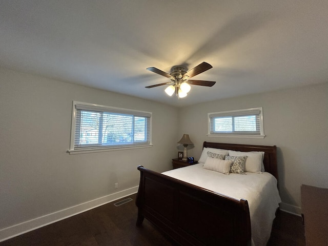 bedroom featuring multiple windows, dark hardwood / wood-style flooring, and ceiling fan