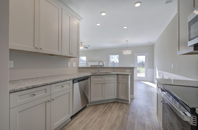 kitchen featuring ceiling fan, kitchen peninsula, sink, and appliances with stainless steel finishes