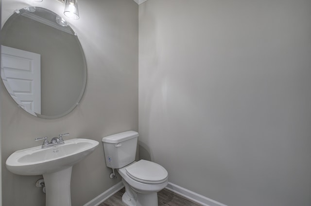 bathroom with hardwood / wood-style floors, sink, toilet, and crown molding