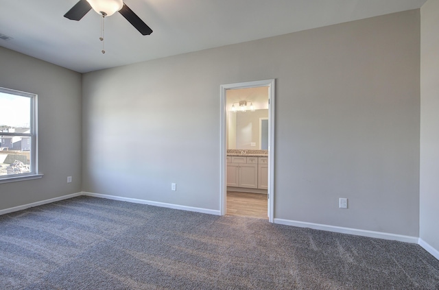 carpeted spare room with ceiling fan