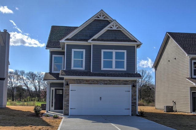 view of front of home with a garage and central air condition unit