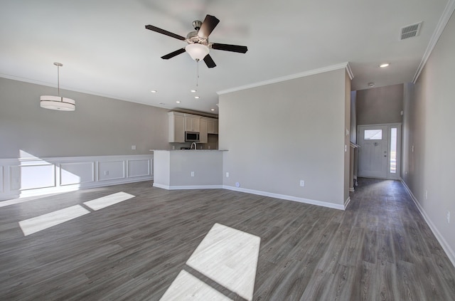 unfurnished living room featuring dark hardwood / wood-style flooring, ceiling fan, and ornamental molding